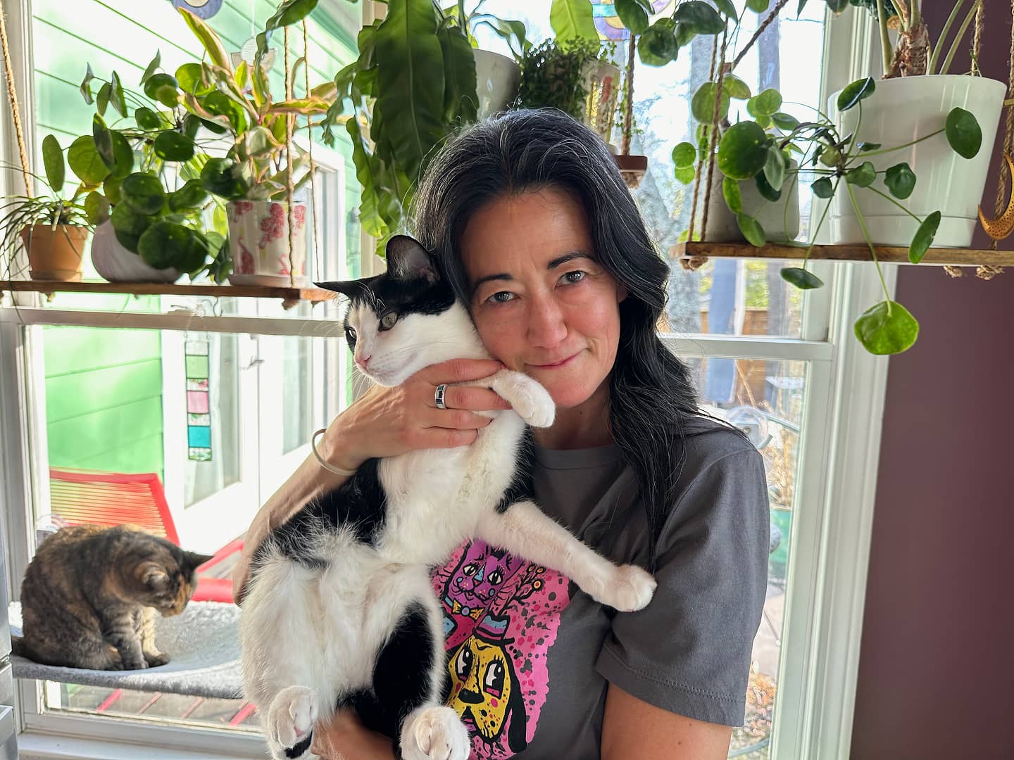 Woman holding black and white cat