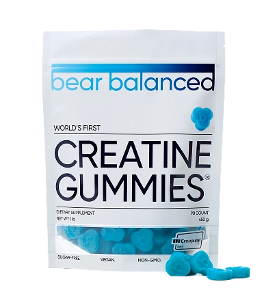 A white pouch of Bear Balanced Creatine Gummies with several blue, bear-shaped gummies in front of it.