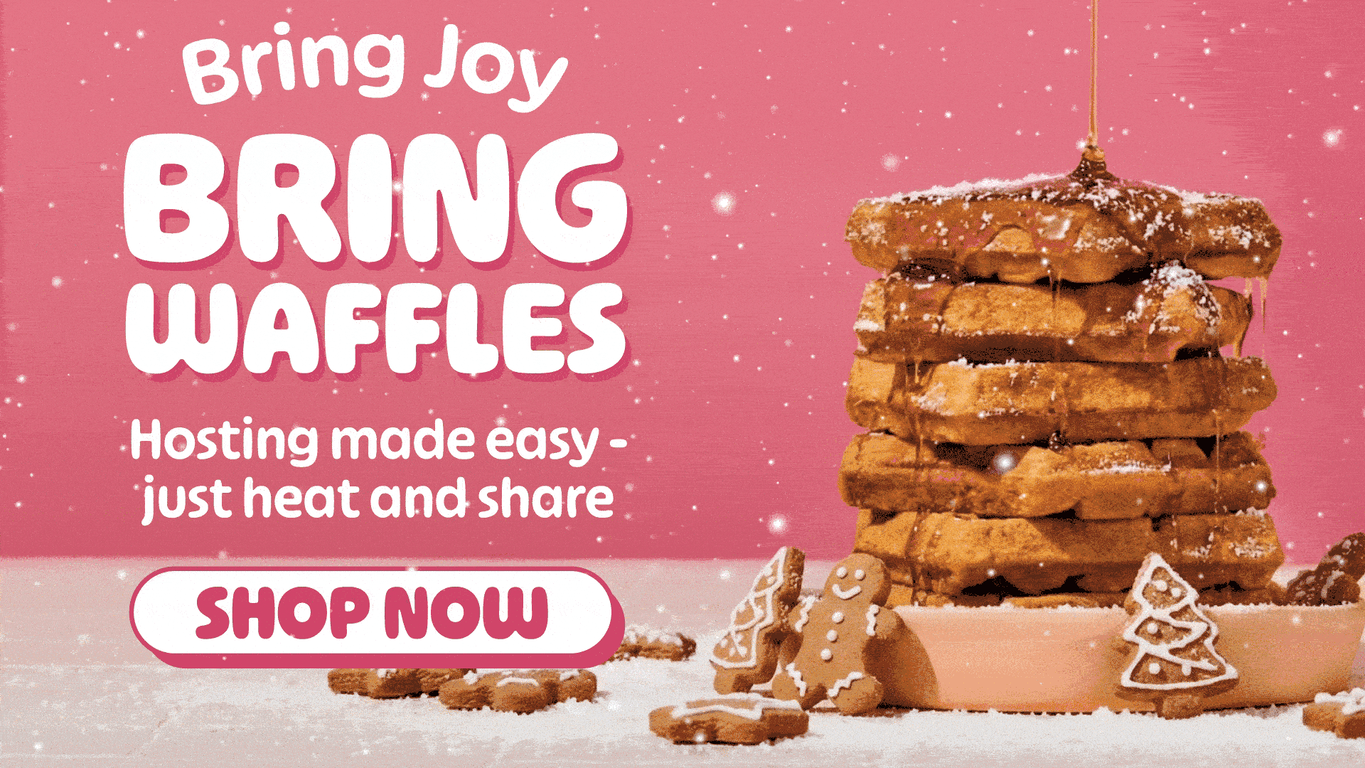 Stack of waffles with gingerbread cookies and syrup on pink background.