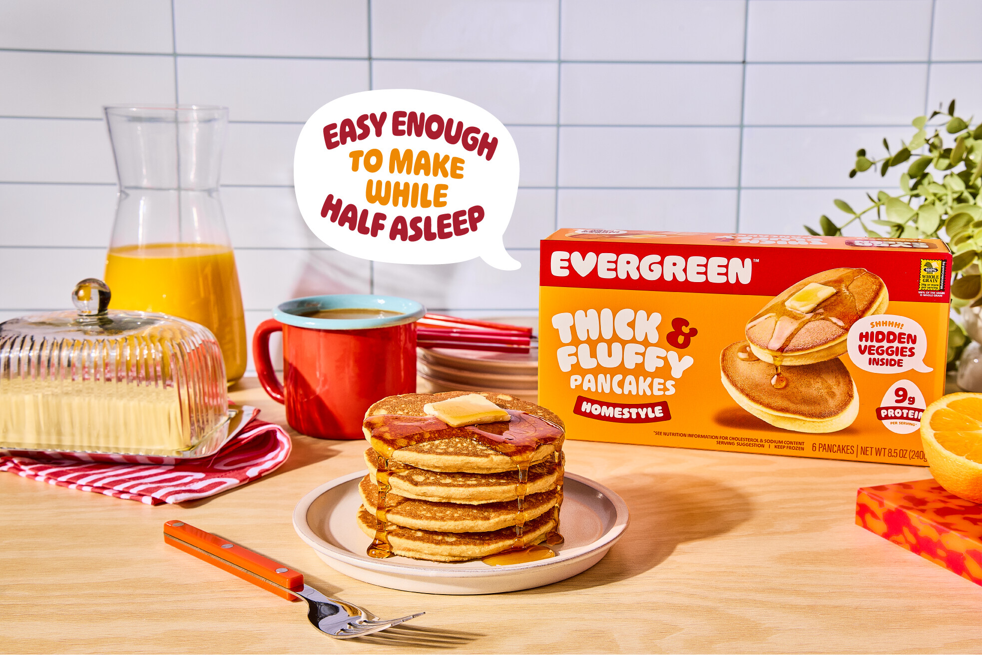 A breakfast table with a stack of pancakes next to a box of Evergreen Thick & Fluffy Pancakes.