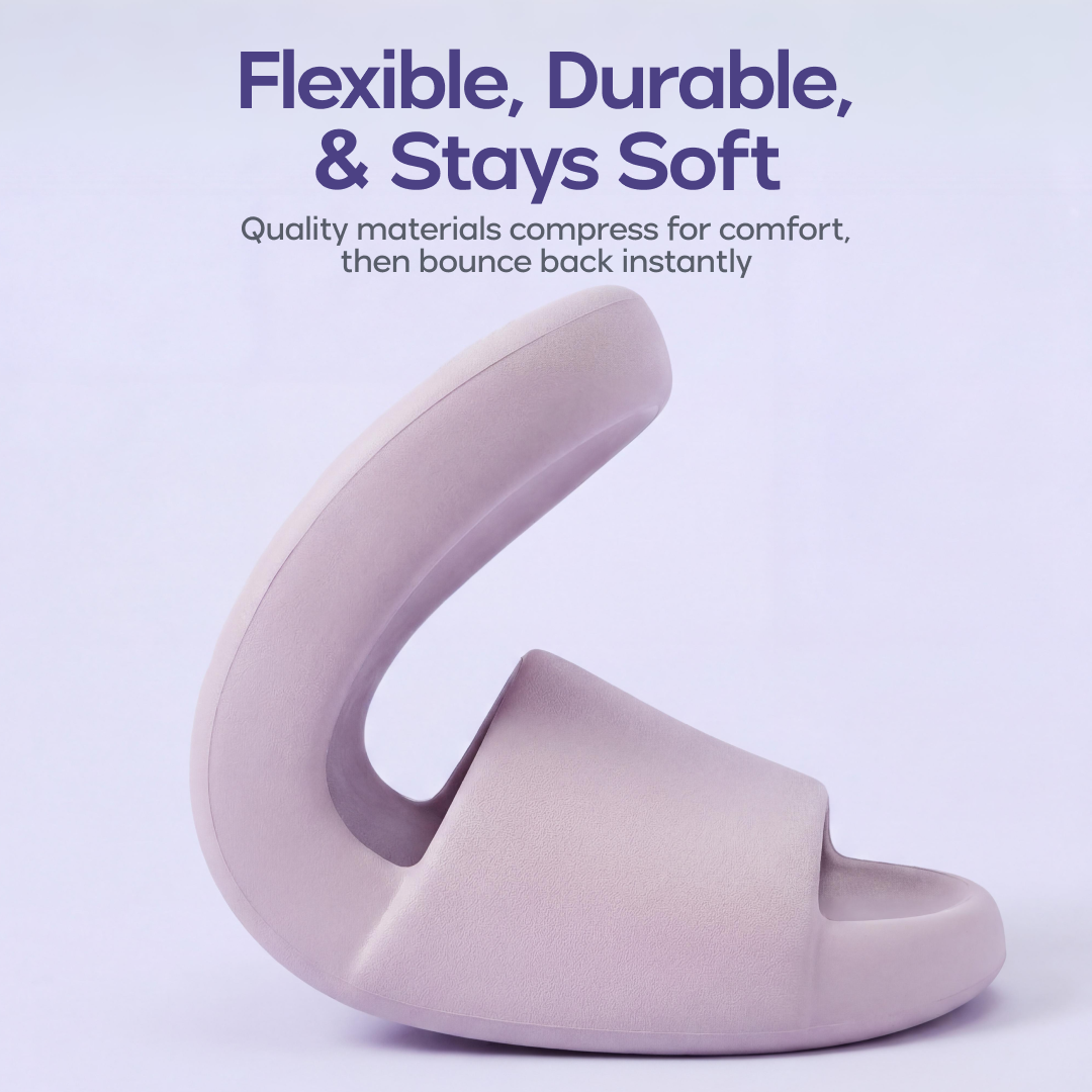 A flexible light purple slide sandal is bent upwards to demonstrate its soft, durable material.