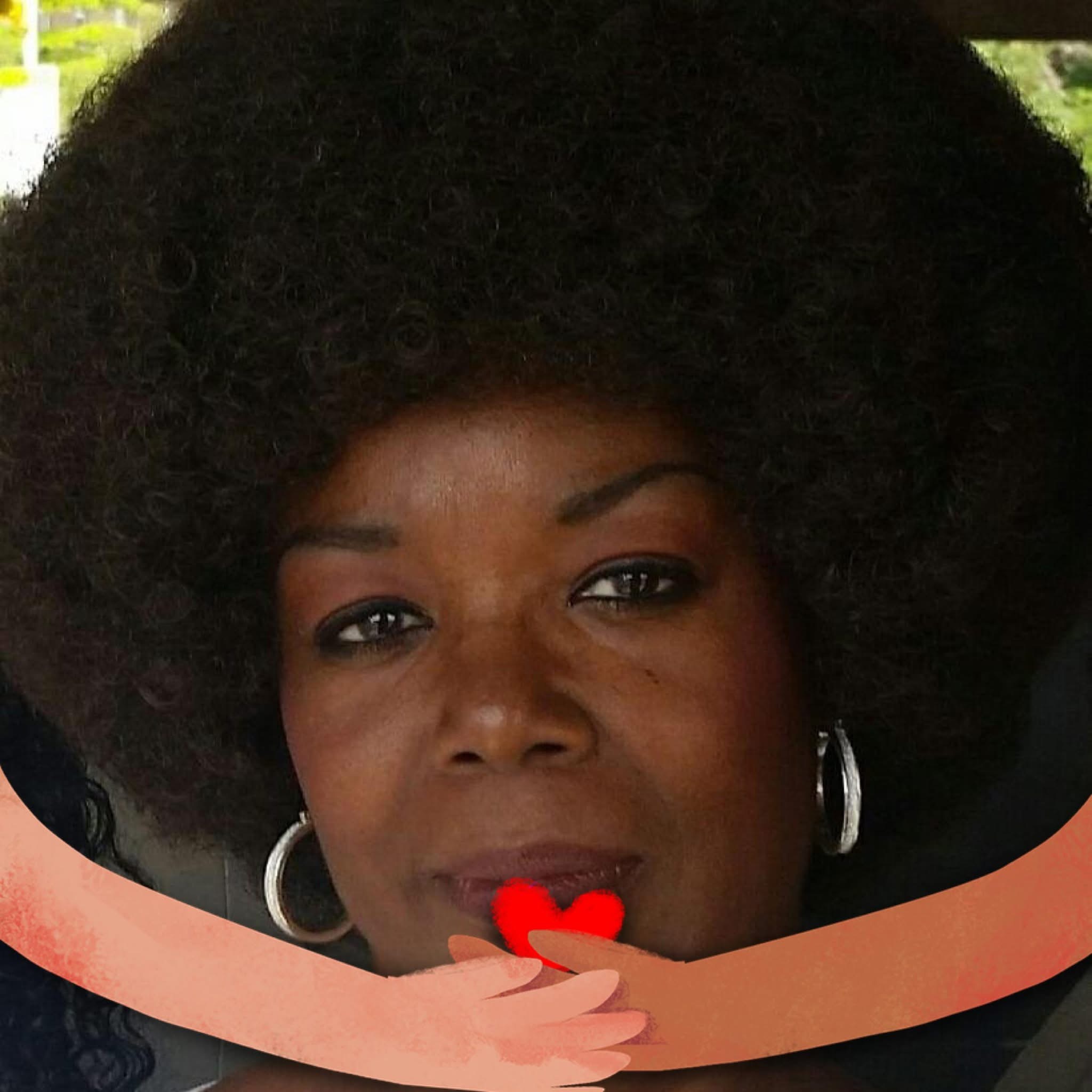 Close-up portrait of a person with afro hairstyle, holding a red heart and hoop earrings.