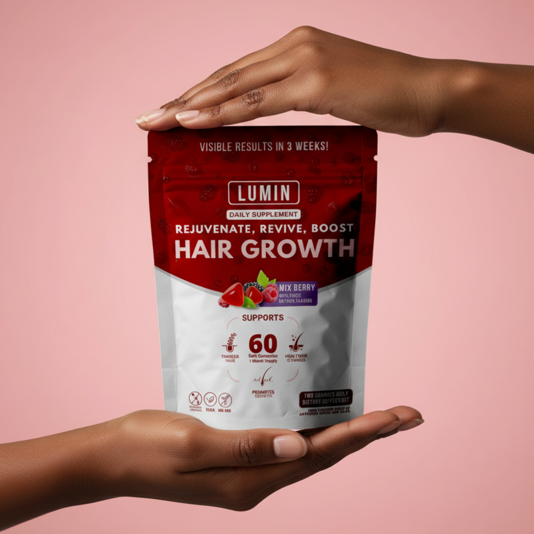 Hands holding a Lumin hair growth supplement package on a pink background.