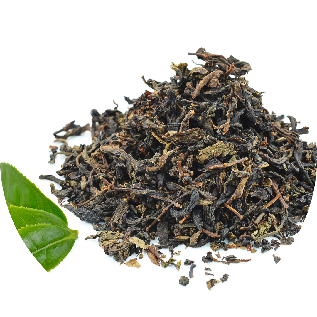 A pile of dried, loose-leaf black tea next to two fresh green tea leaves.