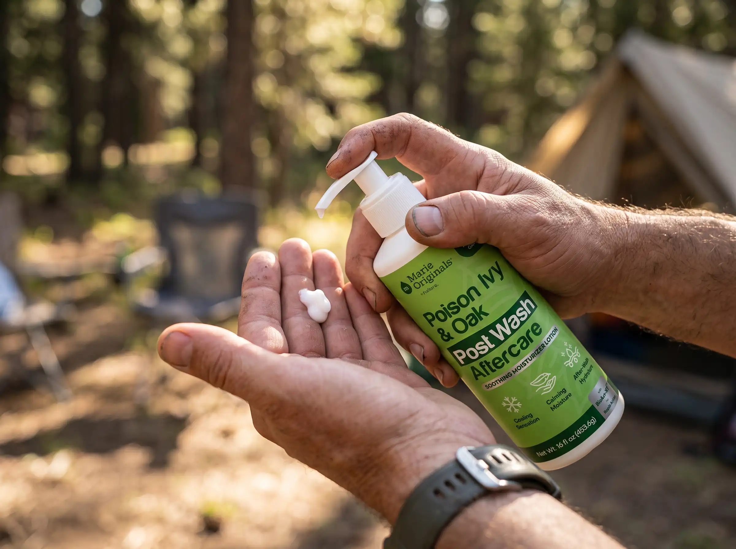 A person pumps a bottle of Poison Ivy & Oak Post Wash Aftercare lotion into their hand outdoors.