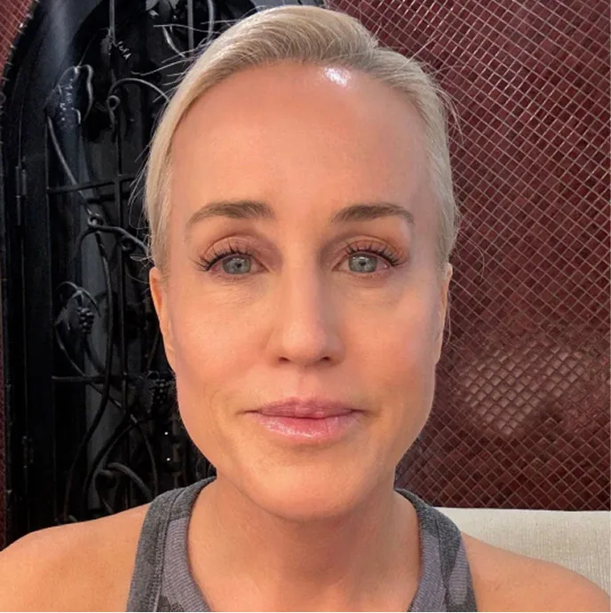 A close-up photo of a woman with short blonde hair and light eyes looking at the camera.