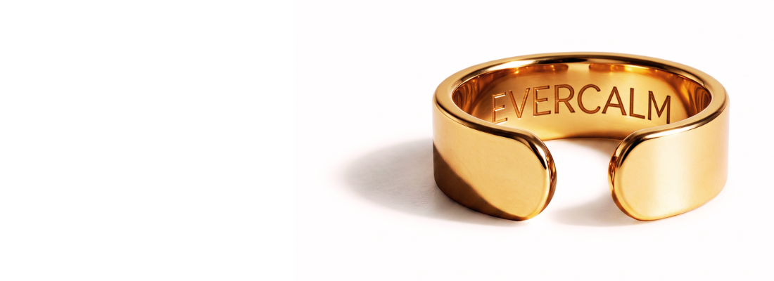 A gold-colored, open-ended ring with the word 'EVERCALM' engraved on the inside, set against a white background.