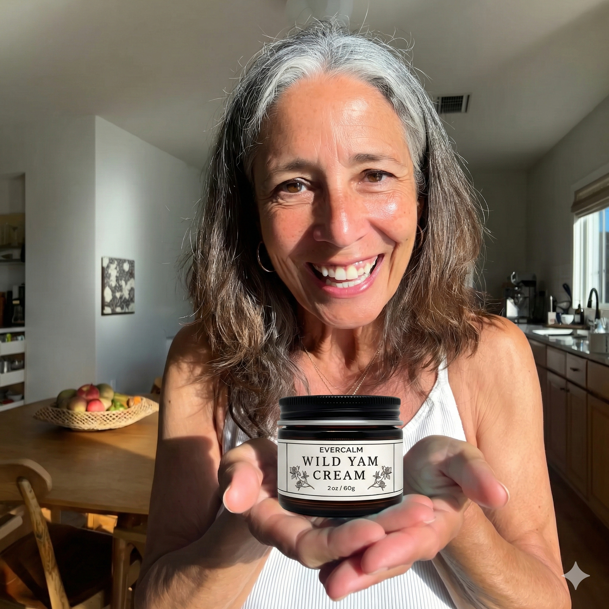 A smiling woman with graying hair holds up a jar of Evercalm Wild Yam Cream in her home.