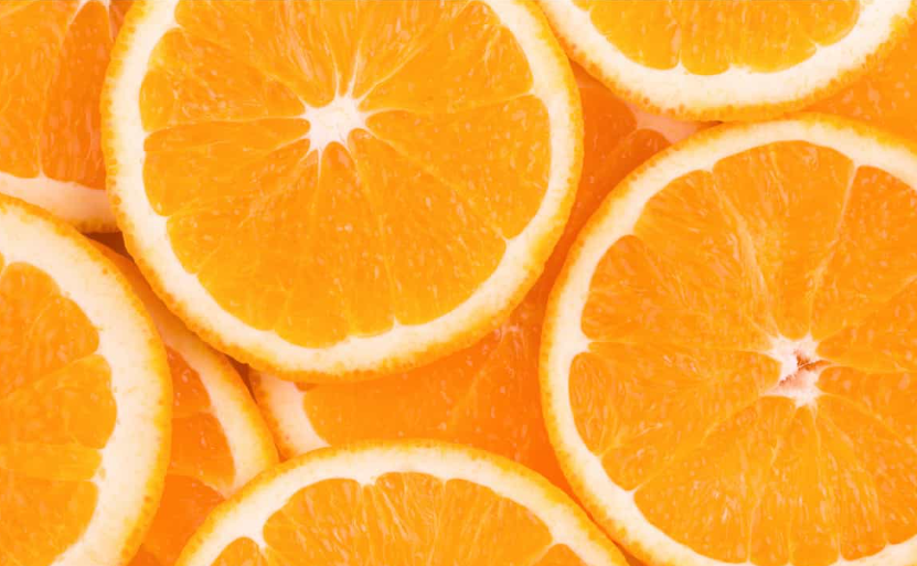 A close-up shot of overlapping fresh orange slices, creating a vibrant background.