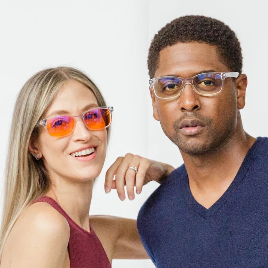 Two people wearing stylish glasses, smiling and posing against a white background.