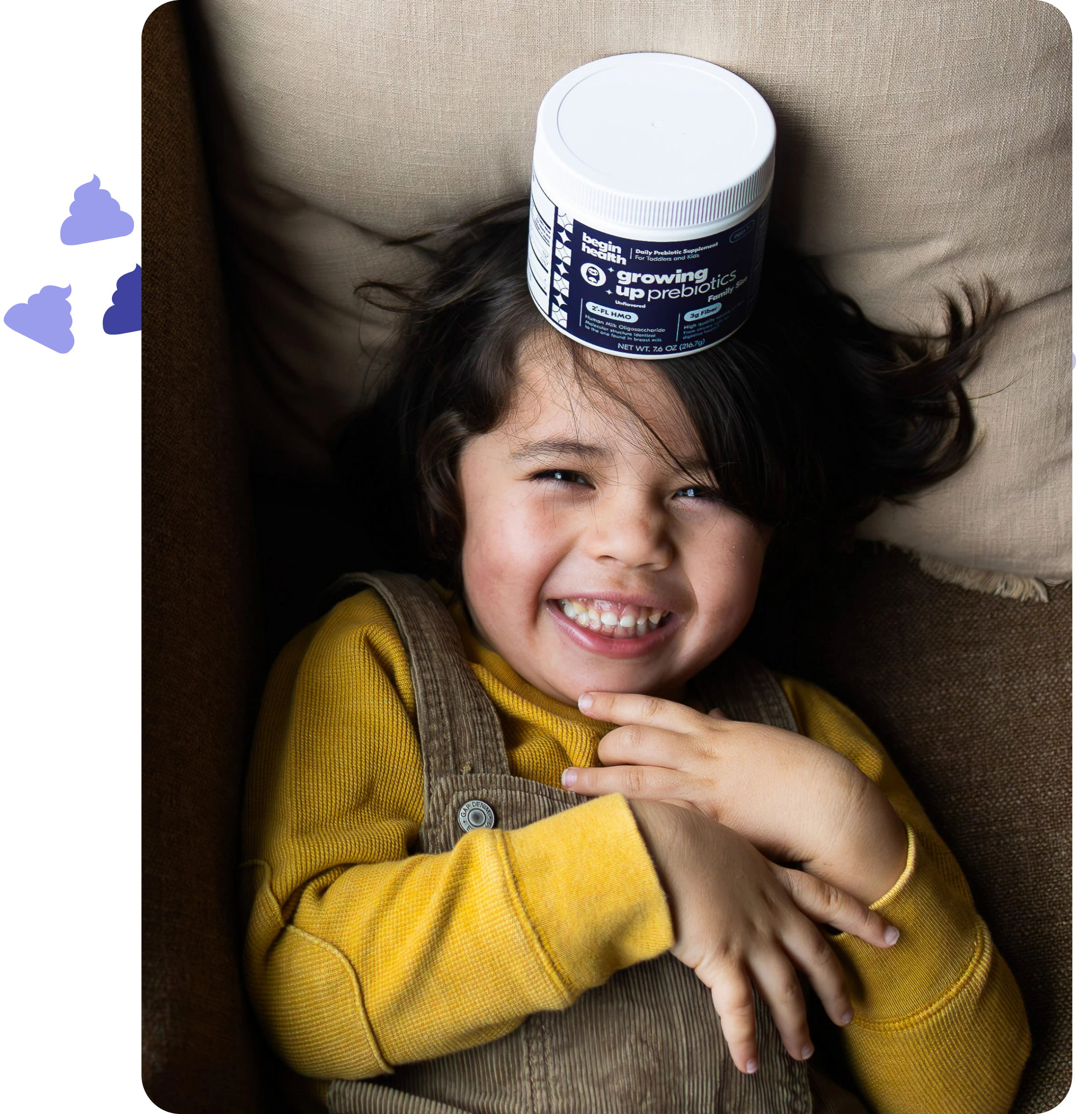 Smiling child with a container on their head, wearing a yellow shirt.