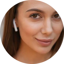 Close-up of a person wearing wireless earbuds, smiling slightly.