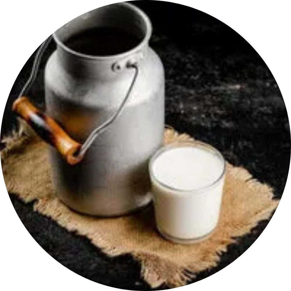 Metal milk can and glass of milk on burlap mat.