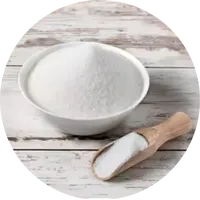 A bowl of white powder with a wooden scoop on a wooden surface.