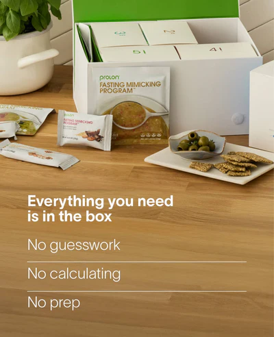 ProLon Fasting Mimicking Program box on a table with included food packets, olives, and crackers.