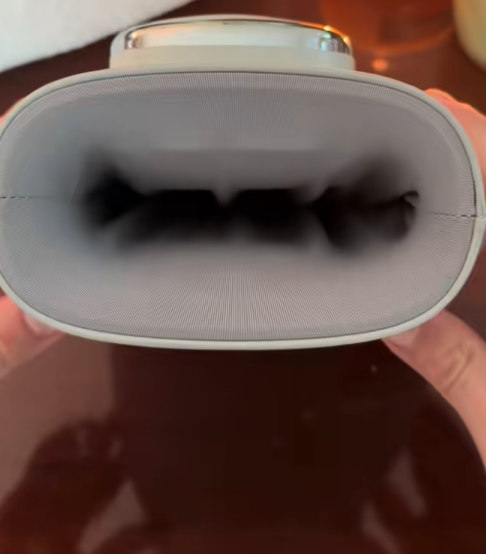 Close-up of hands holding a gray elliptical device with a black interior.