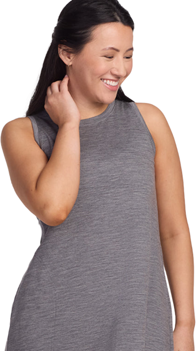Person in a sleeveless gray dress smiling and looking down.