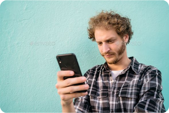 Person in plaid shirt looking at smartphone against a teal background.
