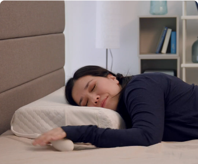Person peacefully sleeping on a supportive, ergonomic pillow in a cozy bedroom setting.