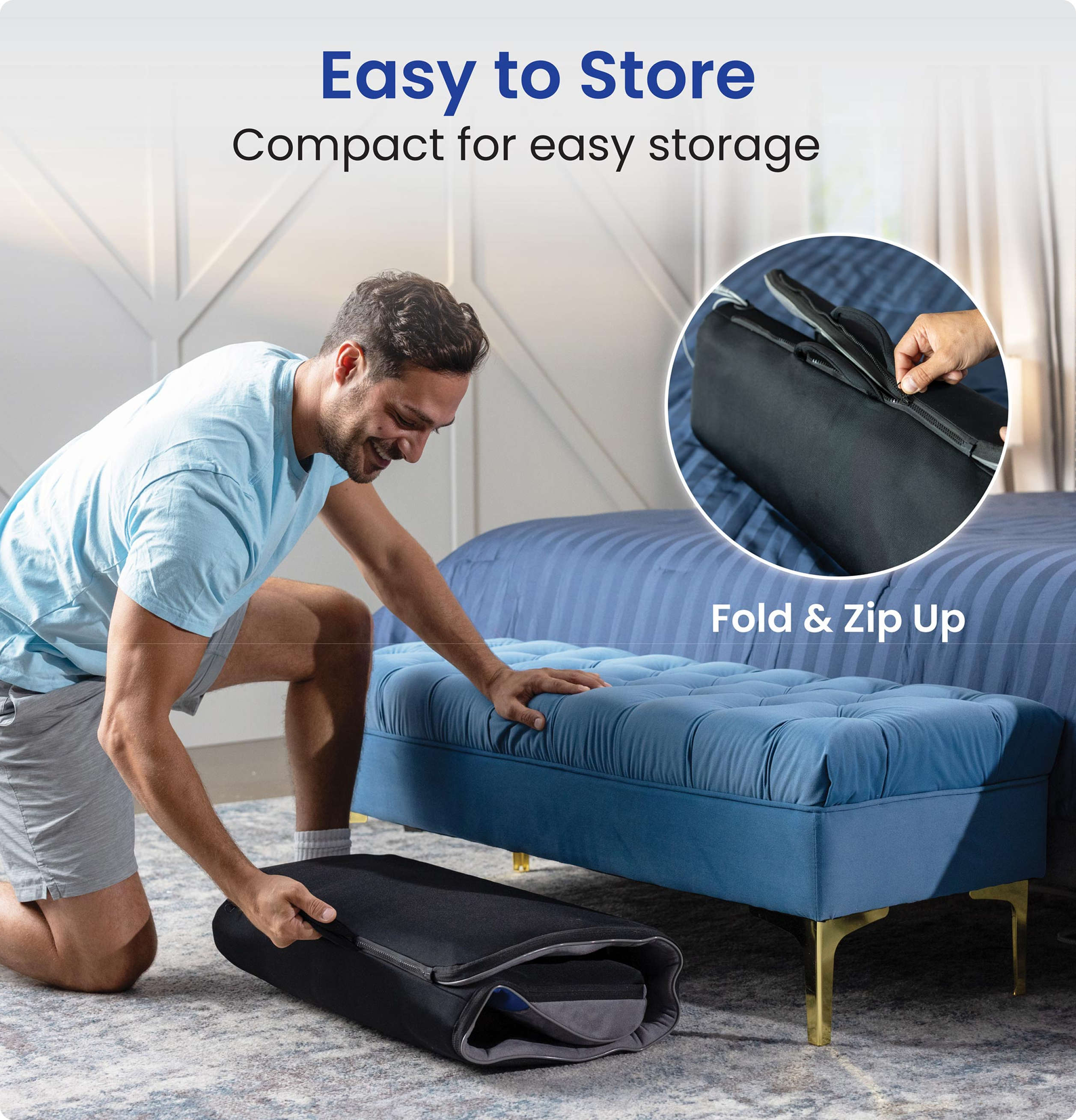Man folding black fabric item near blue furniture in a room.