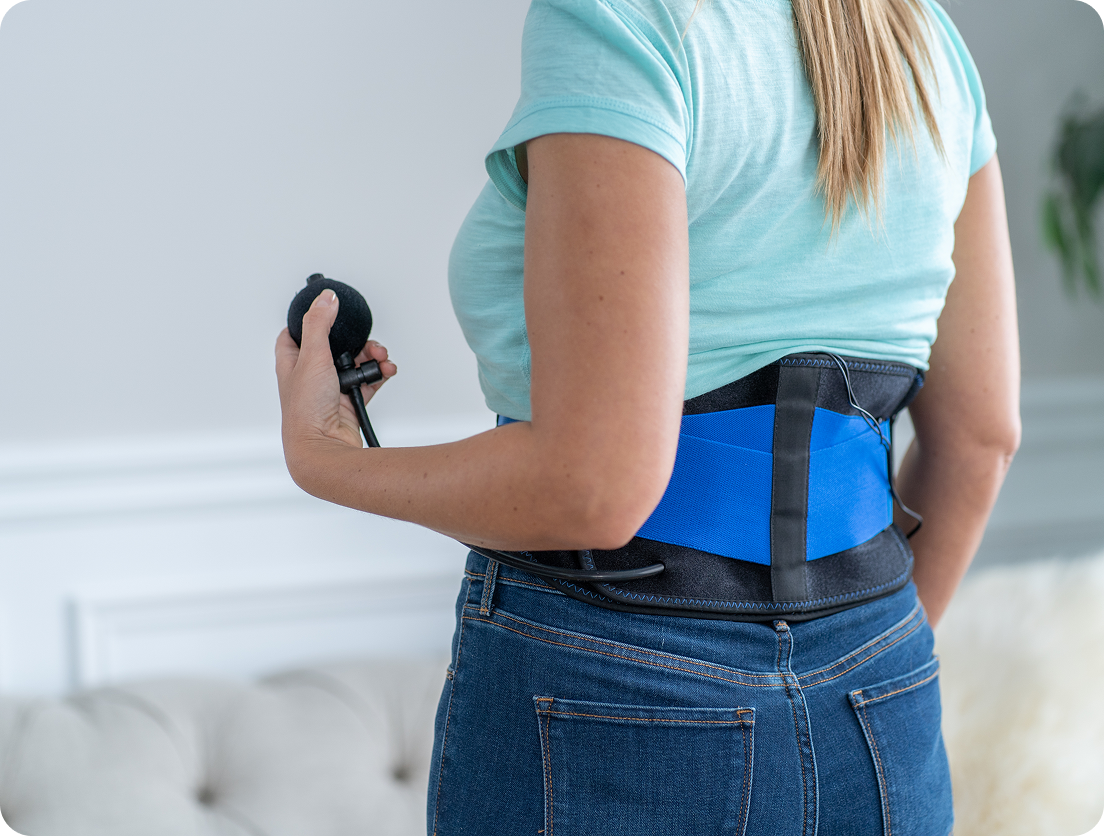Person wearing a blue back brace holding a hand pump.