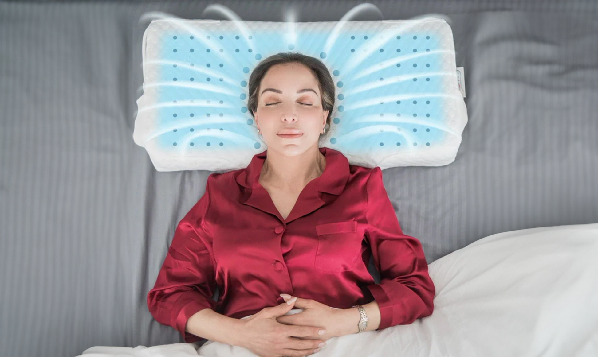 Person sleeping on a cooling pillow with airflow diagram, wearing a red satin pajama top.