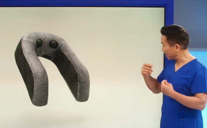 A person in blue clothing looking at a shaped object, possibly a neck pillow.