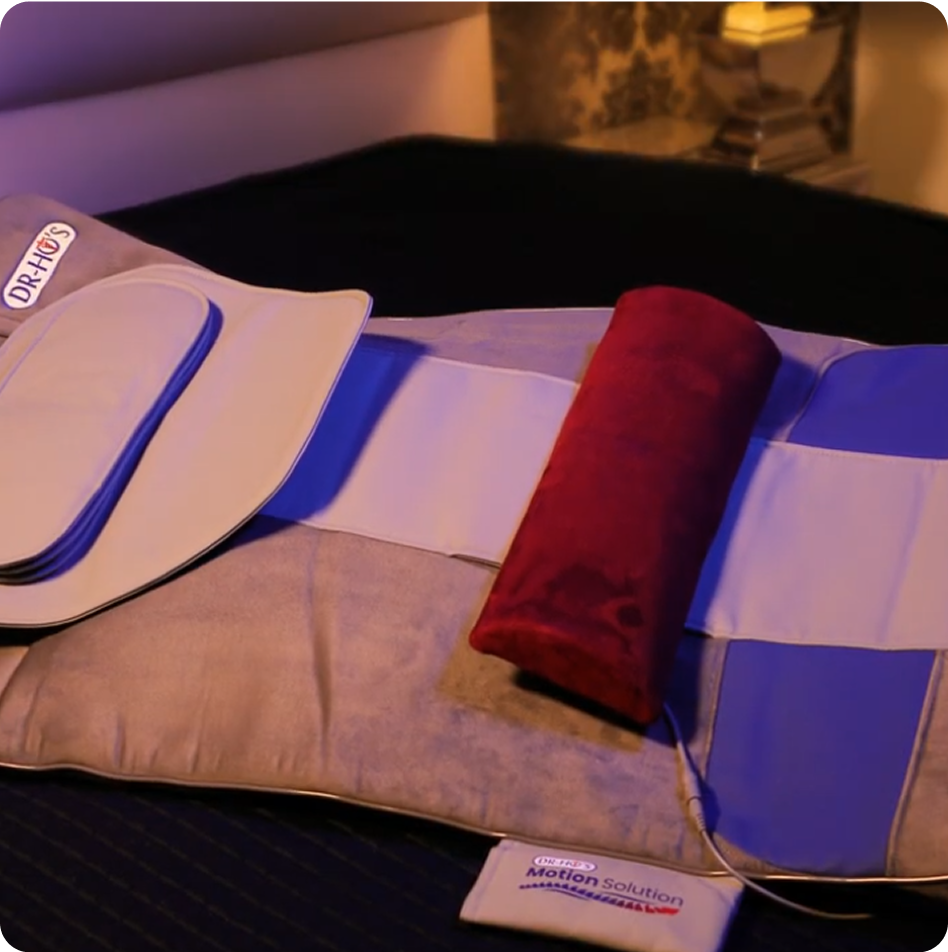 Medical pad device with red cylindrical pillow on a bed.