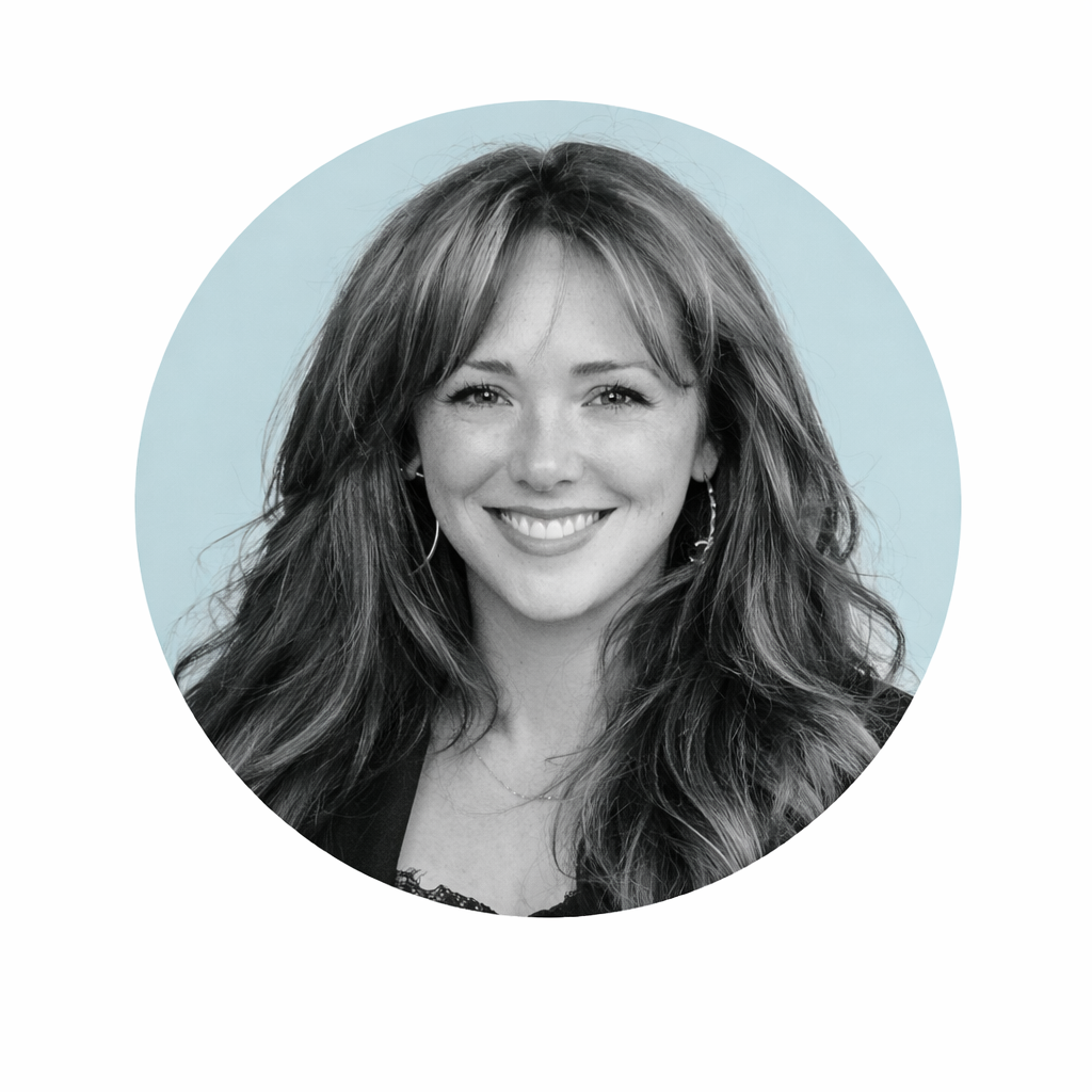 Black and white headshot of a smiling woman with long hair, inside a light blue circle.