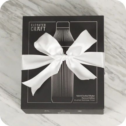 Black box with a white ribbon, labeled 'Elevated Craft' on a marble surface.