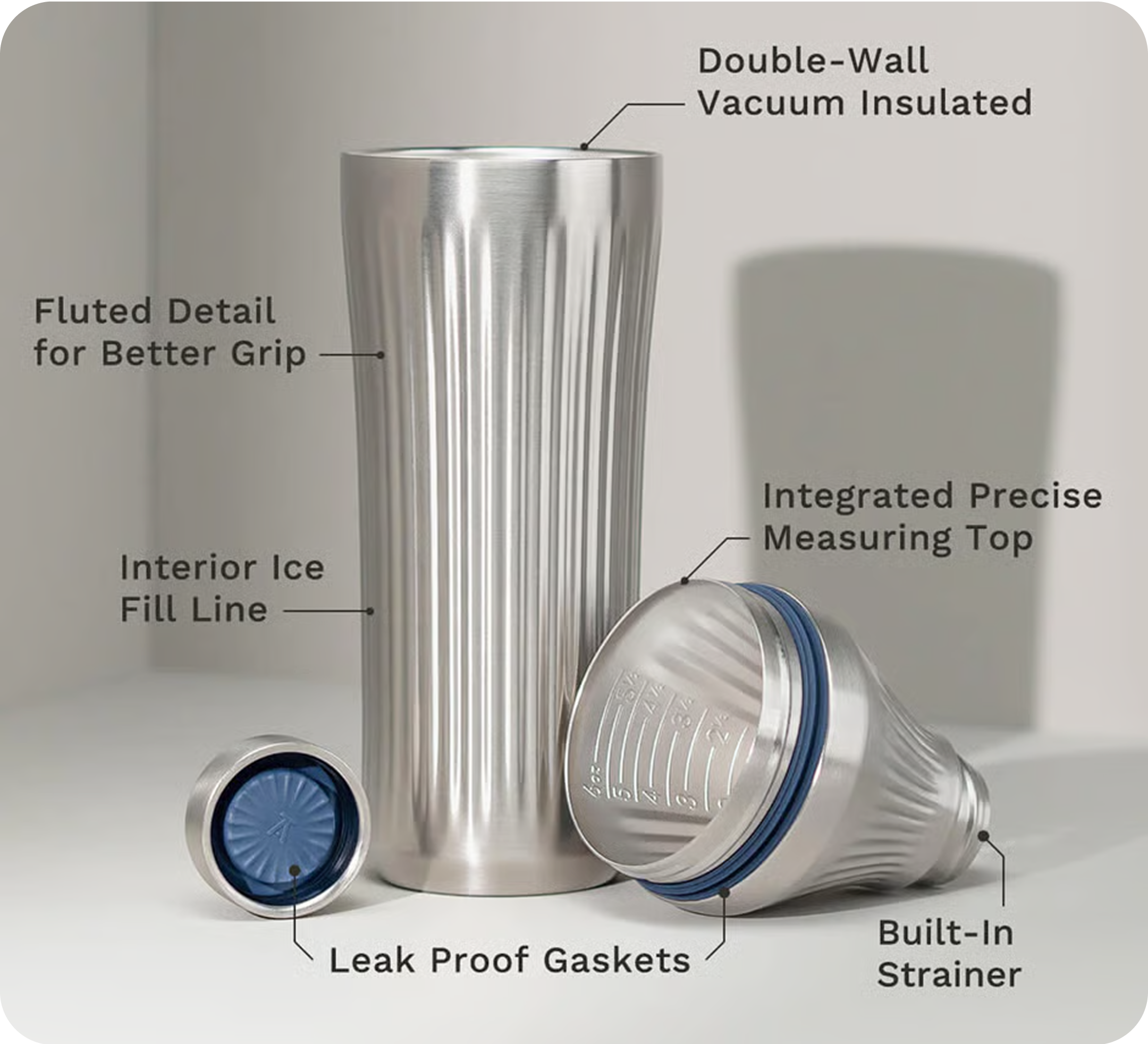 Stainless steel tumbler with fluted design, measuring top, and built-in strainer, labeled features.