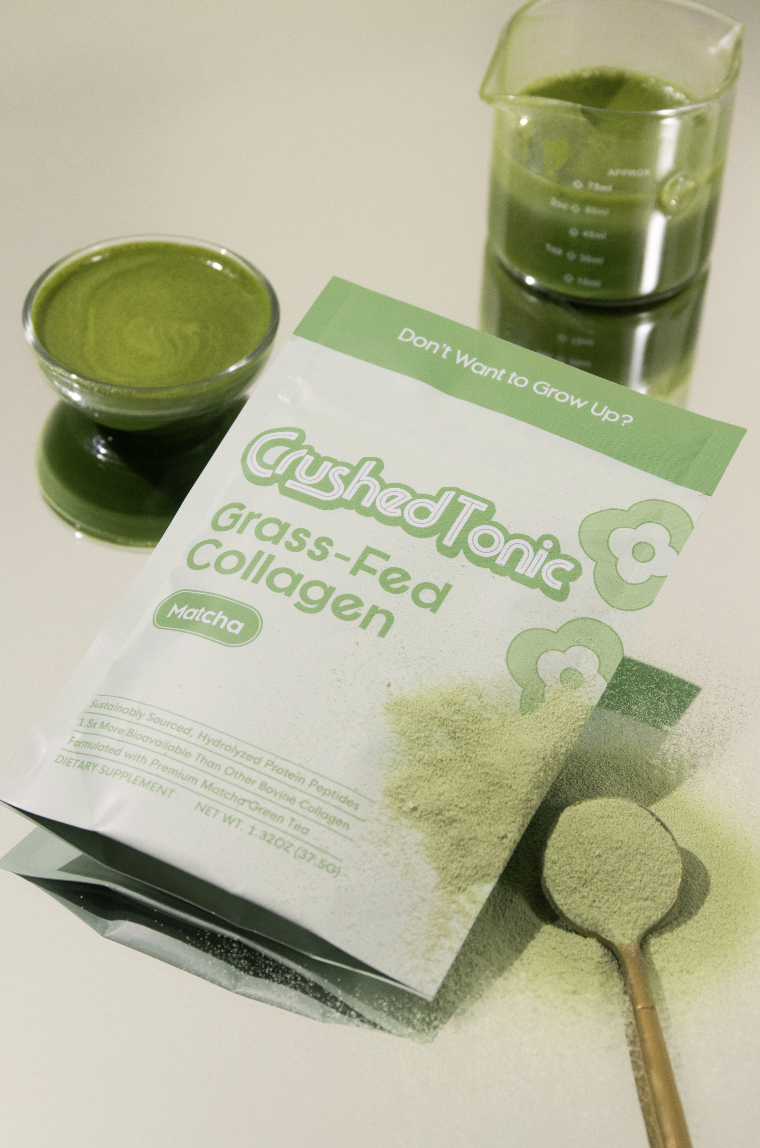 A pouch of Crushed Tonic Matcha Collagen powder next to prepared matcha drinks and a spoon of powder.