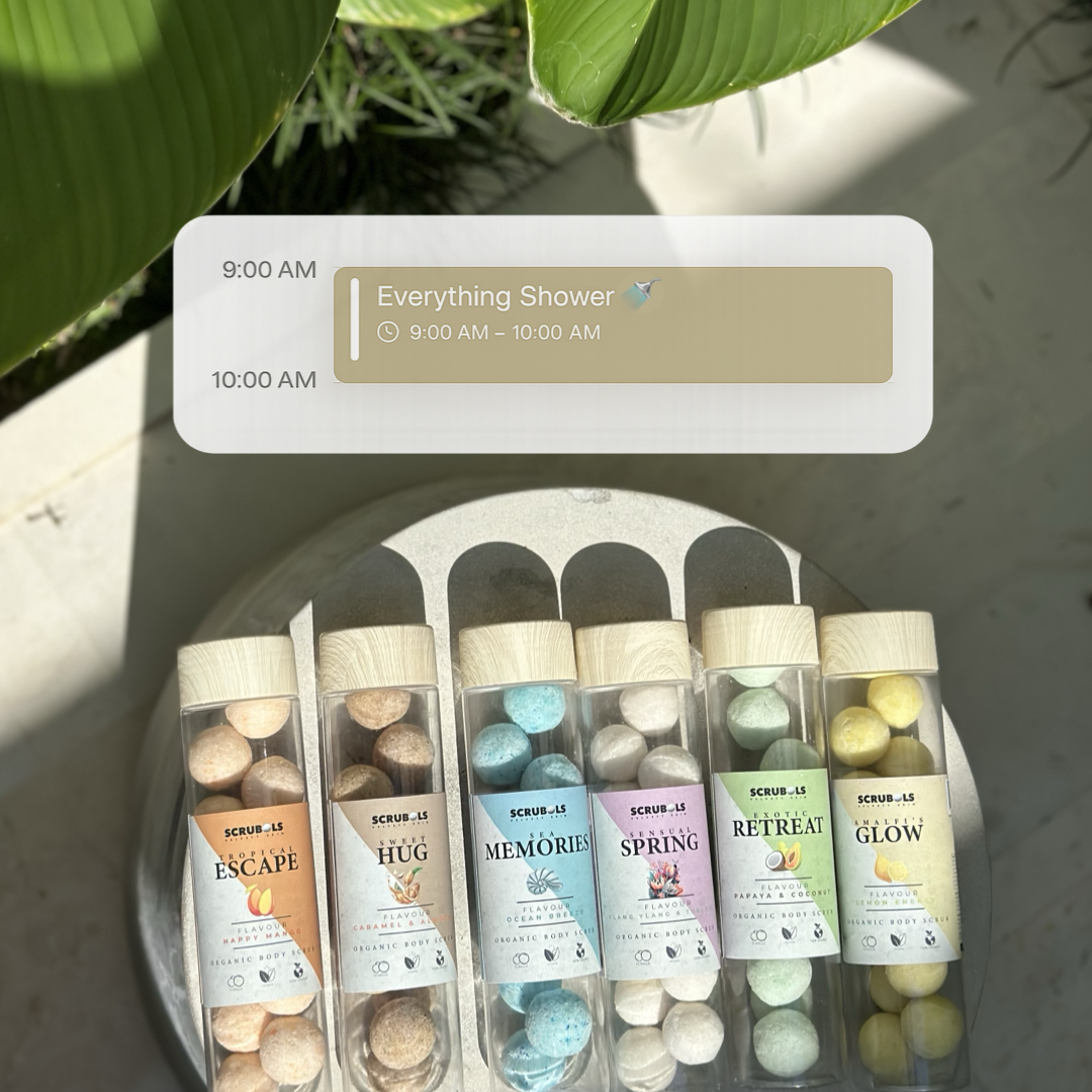 Tubes of colorful body scrubs on a stone surface with a digital calendar graphic overlaid on top.