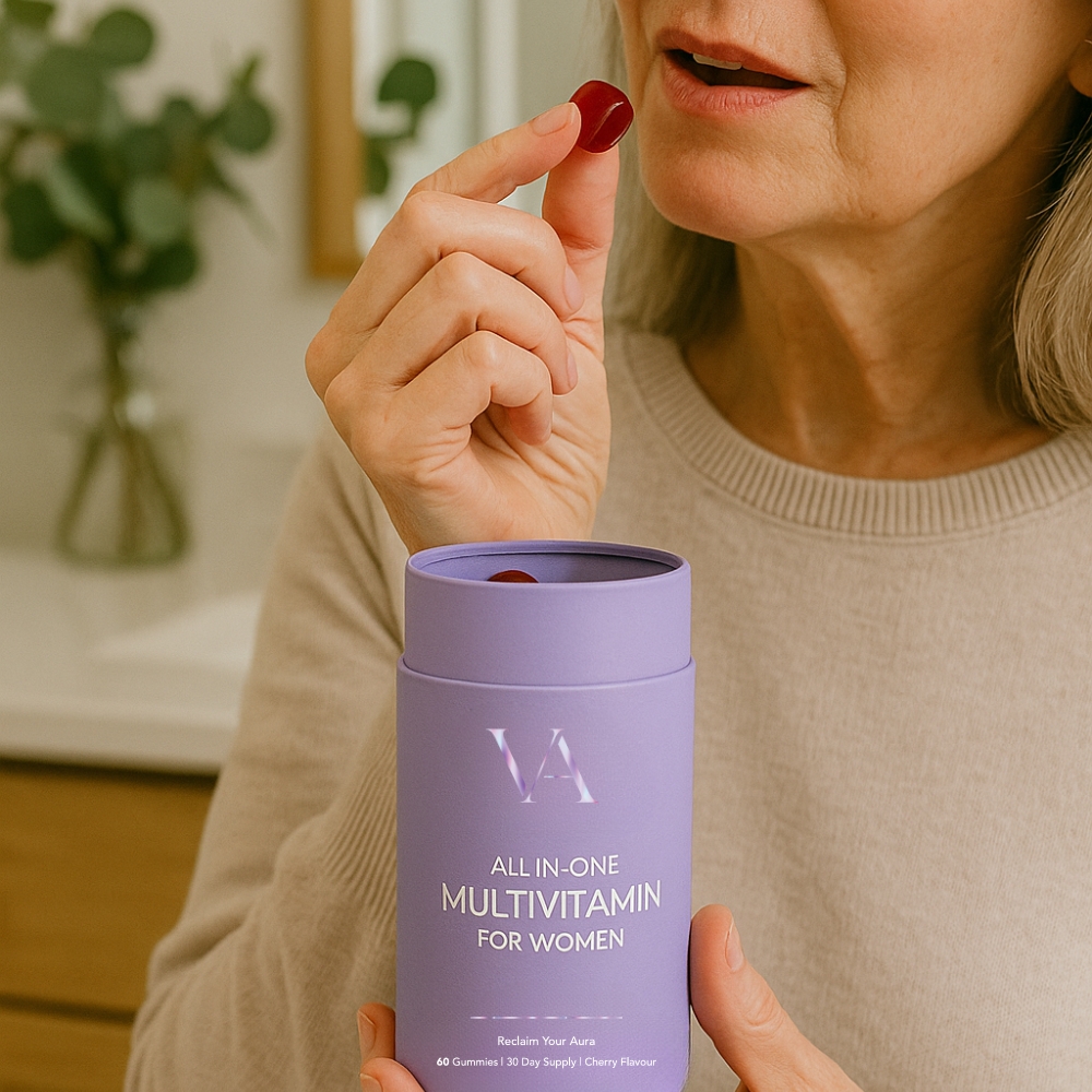 Woman holding a multivitamin gummy and container.