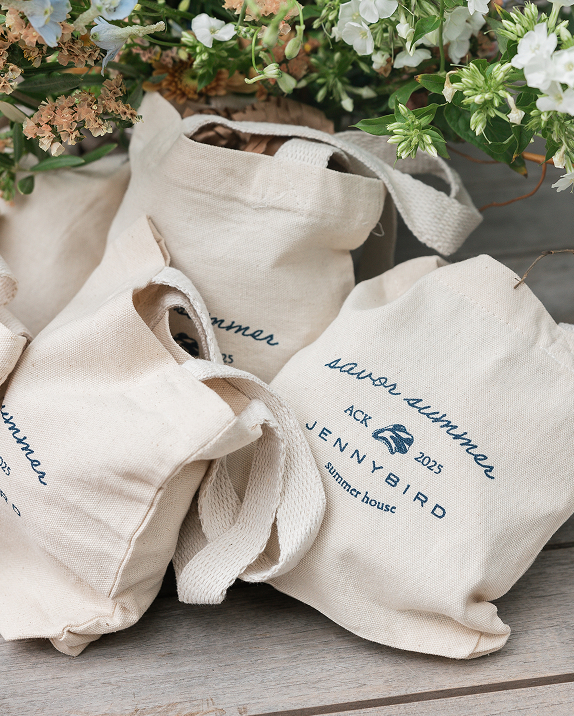 Canvas bags with floral arrangement in the background.