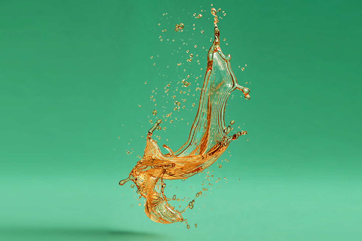 Golden splash of liquid against a green background.