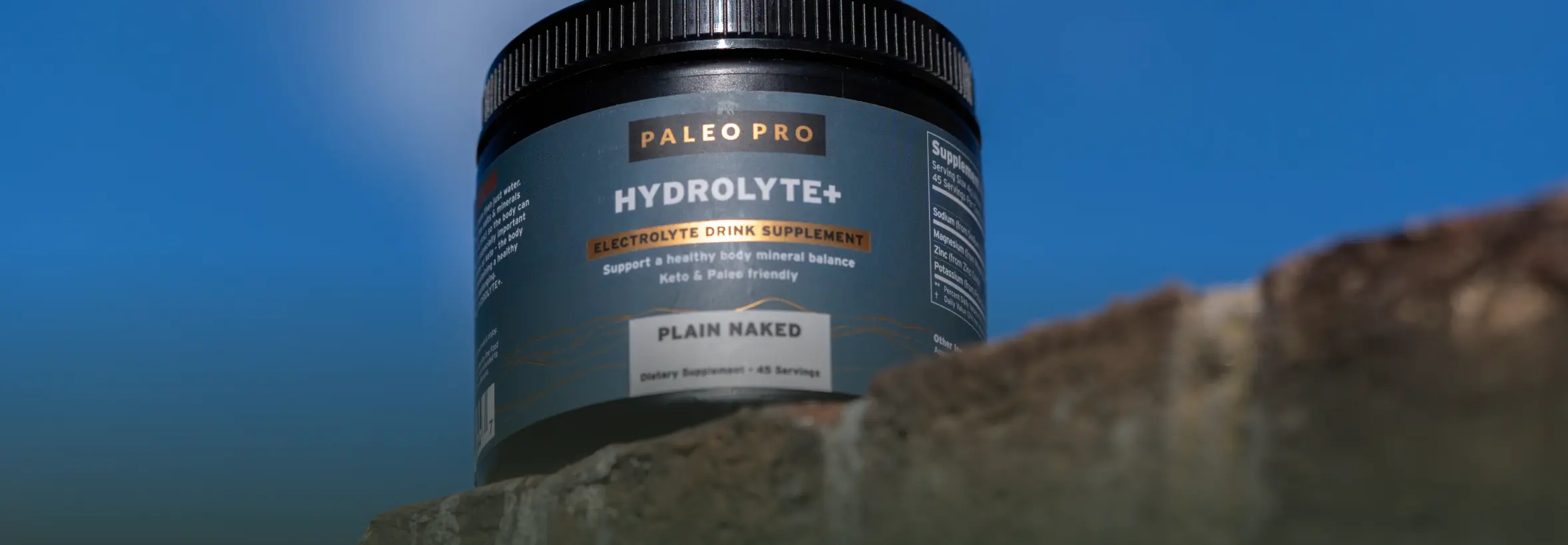A jar of Paleo Pro Hydrolyte+ against a blue sky background.