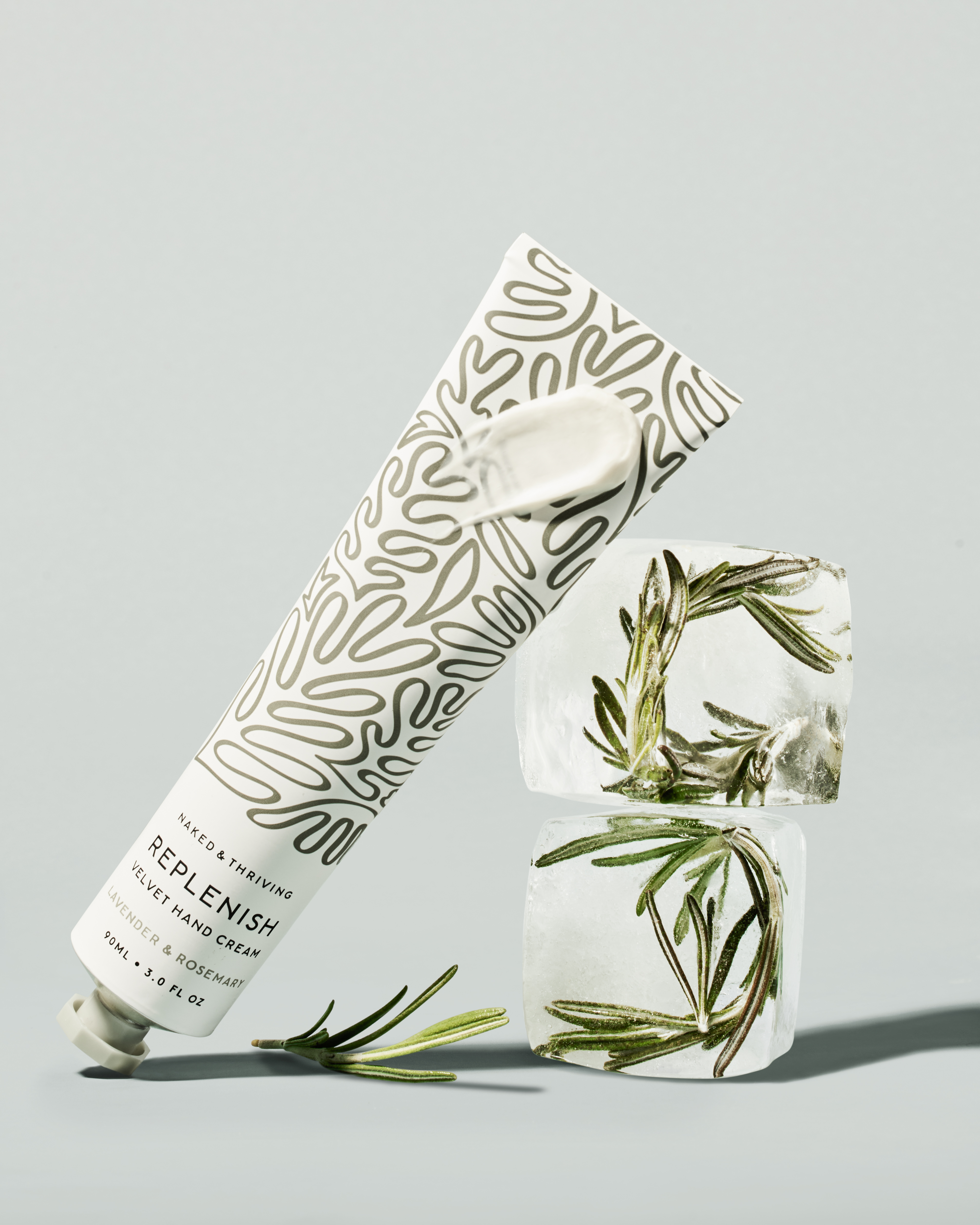 Two white pump bottles on a minimalist background with green leaves.