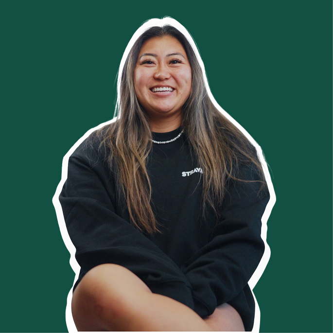 Person smiling, wearing a black sweatshirt, on a teal background.