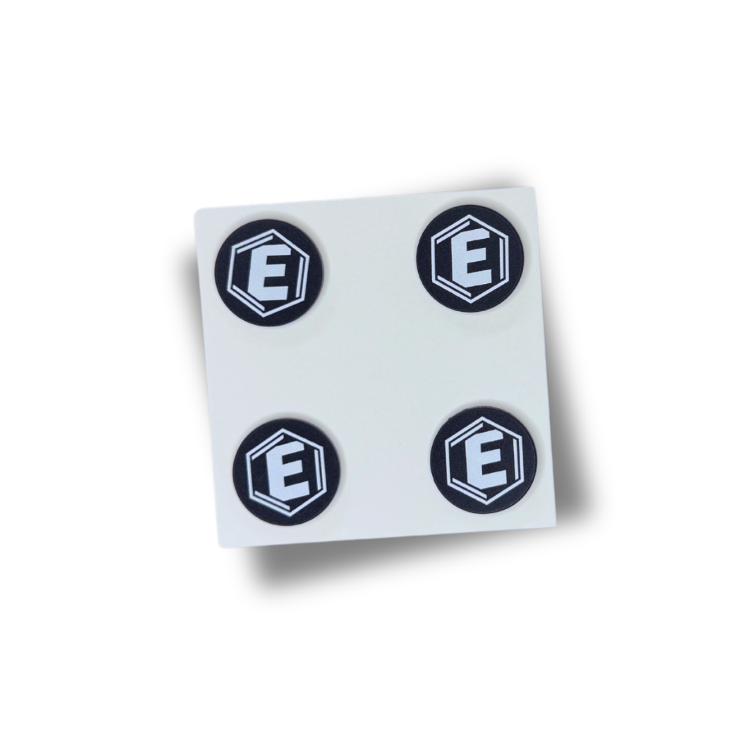 A square sheet of four round, black stickers with a white letter 'E' in a hexagon.