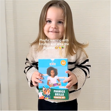 Child holding a box labeled 'Phonics Skills Starter Set' with a cartoon fox.