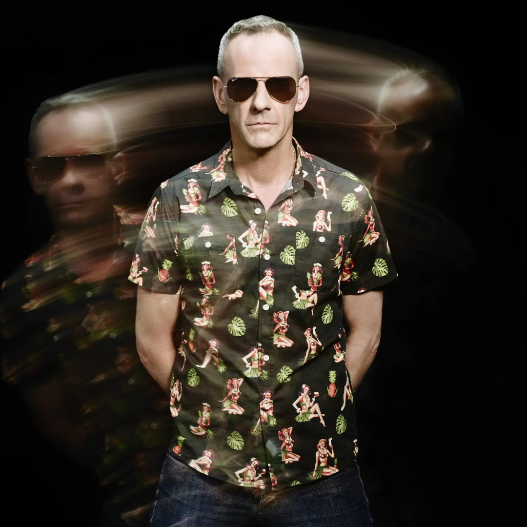 Man in sunglasses and patterned shirt with motion blur effect.