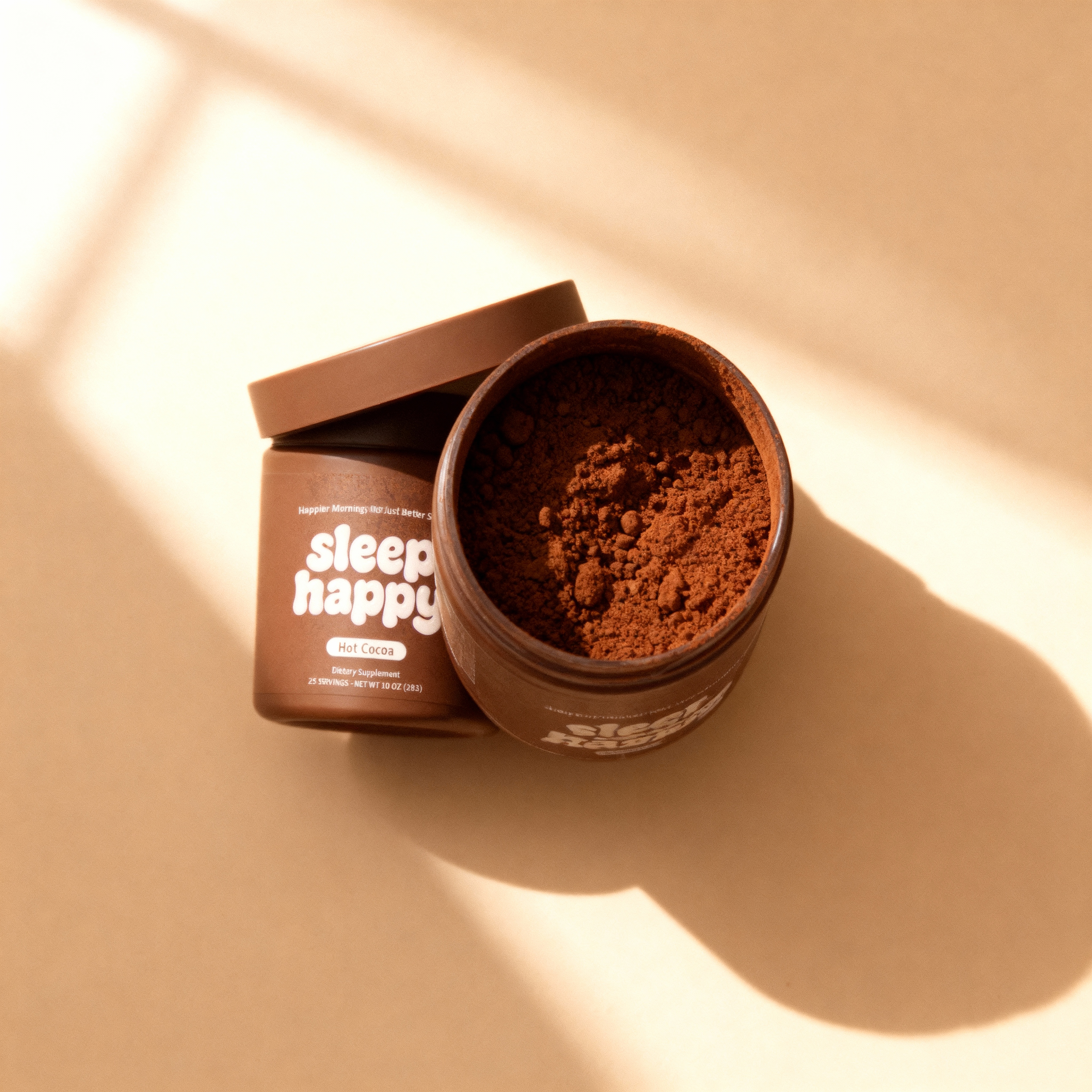 Brown jar of hot cocoa powder labeled 'sleep happy' on a beige background.