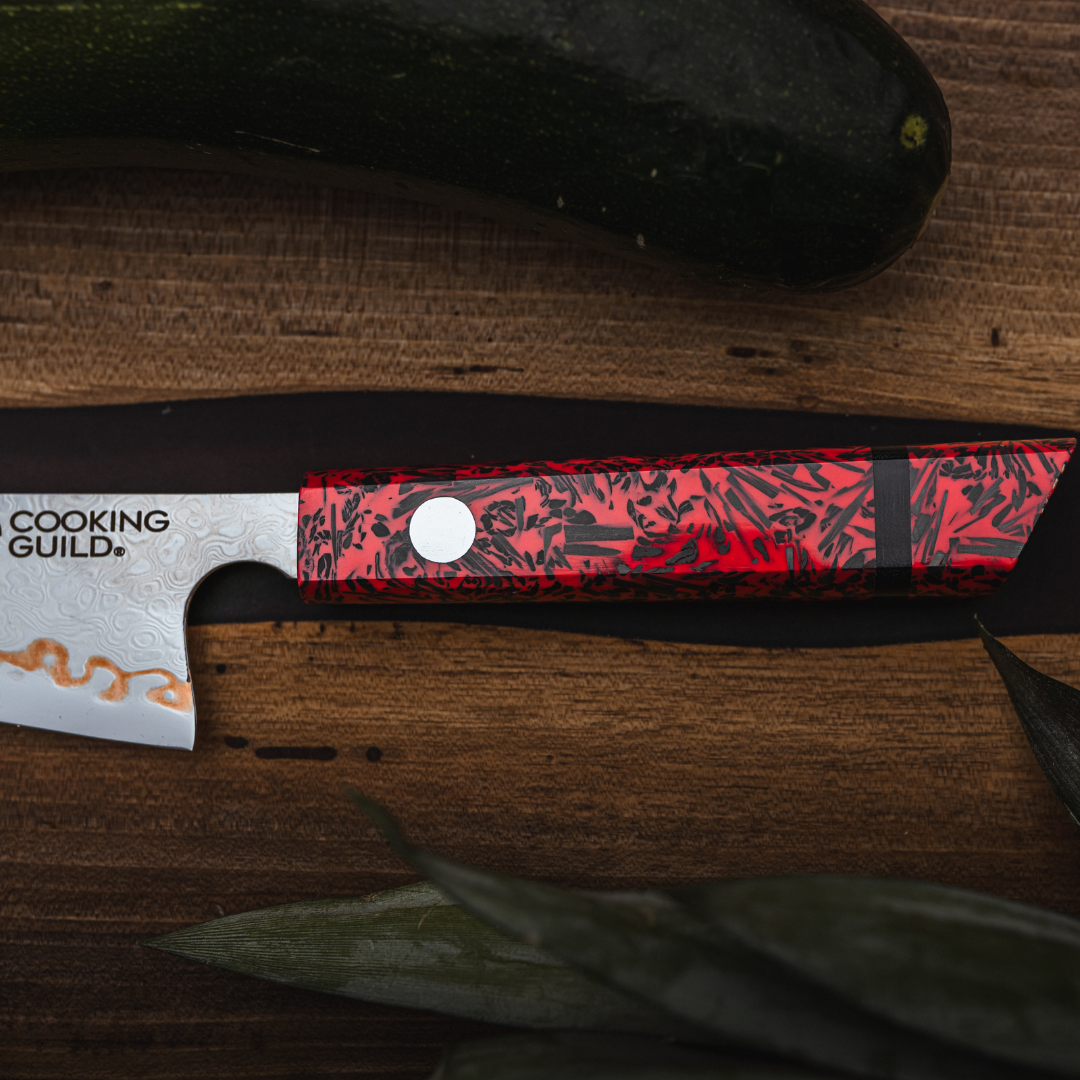 A knife with a red and black handle on a wooden surface.