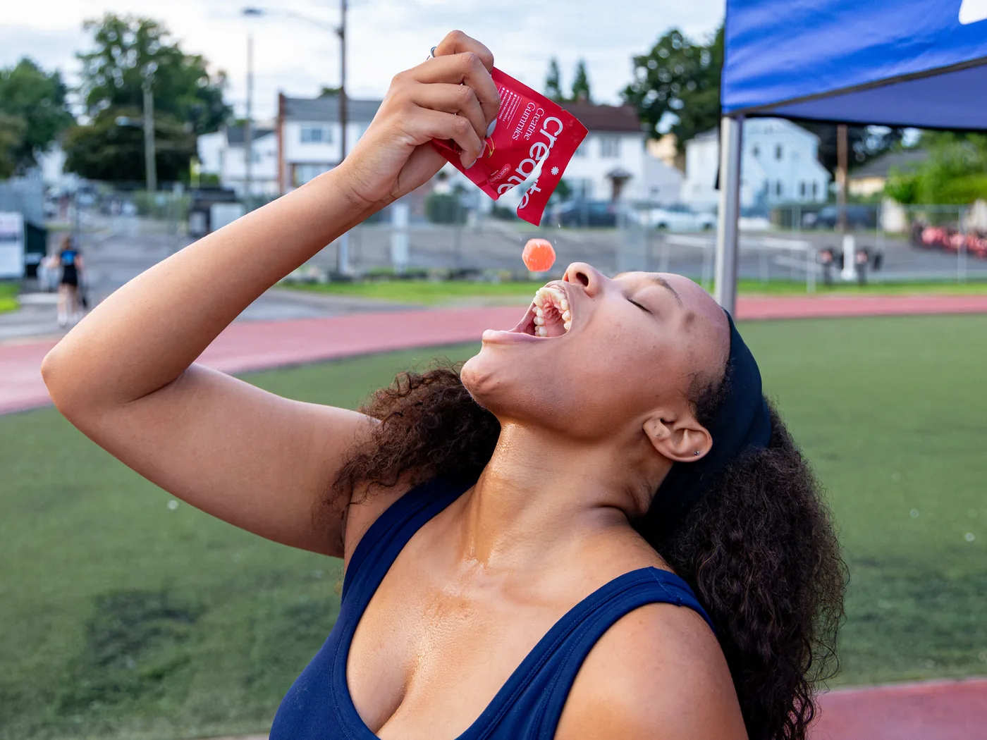 A runner at a run club catching a Create gummy tossed from a red pack