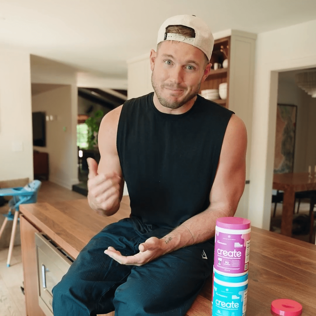 Man sitting on a kitchen counter with supplement containers.