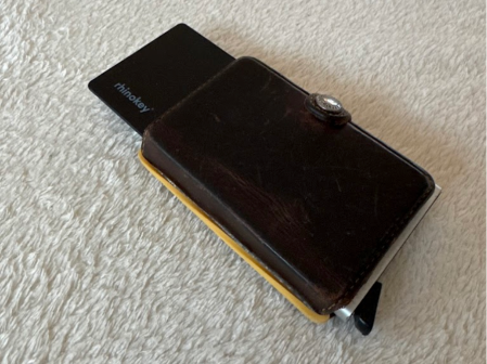 A dark leather wallet with a card partially inserted.