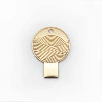 A gold circular USB drive with a wave pattern.