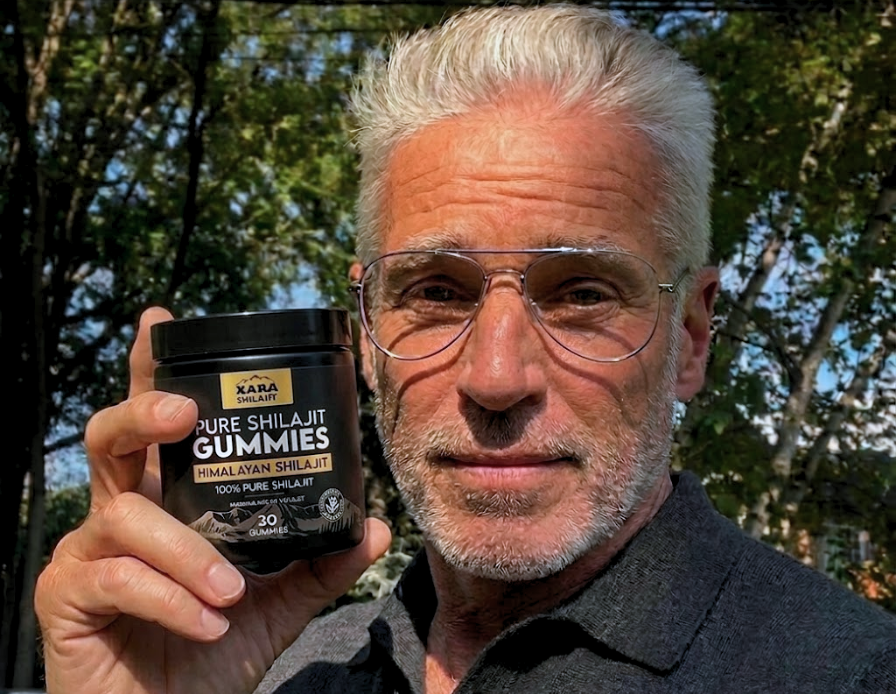 A man with white hair and glasses holds a black jar of Xara Shilajit Pure Shilajit Gummies.