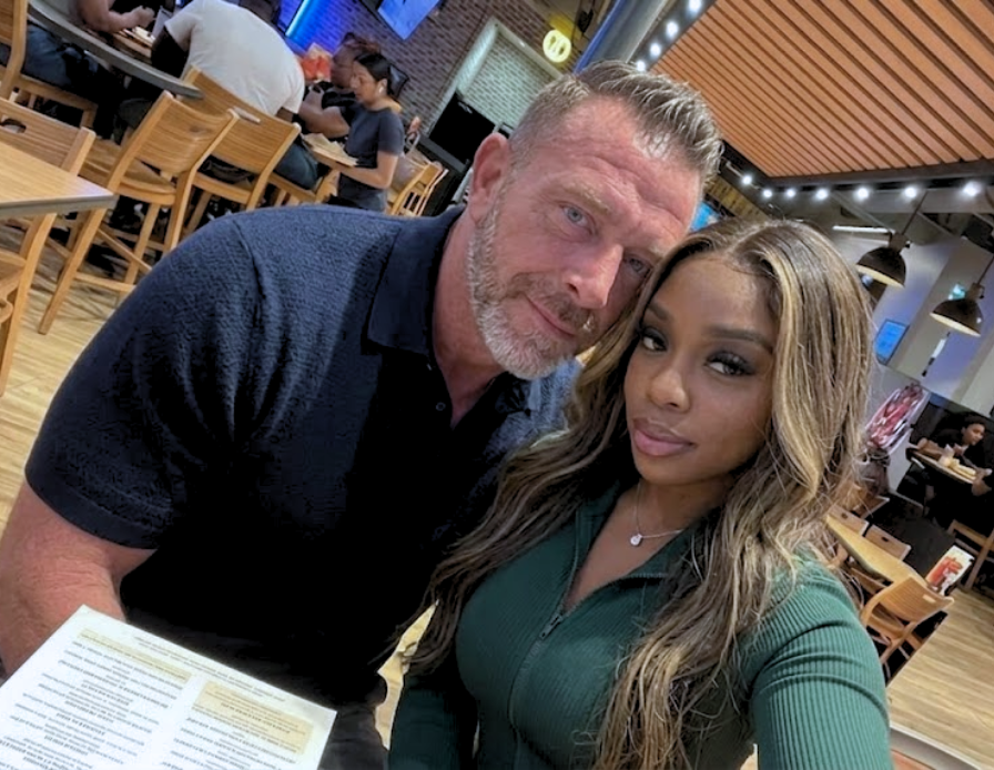 A man and a woman take a selfie together in a restaurant.